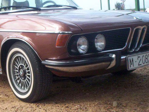 BMW clásico marrón con neumáticos de banda blanca fina