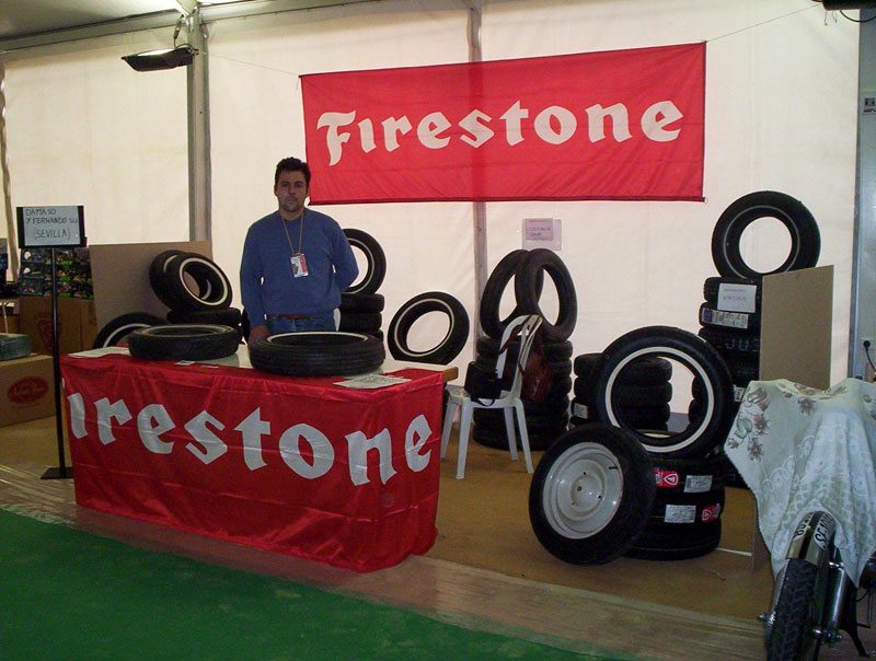 Stand de la empresa en feria con neumáticos de banda blanca expuestos